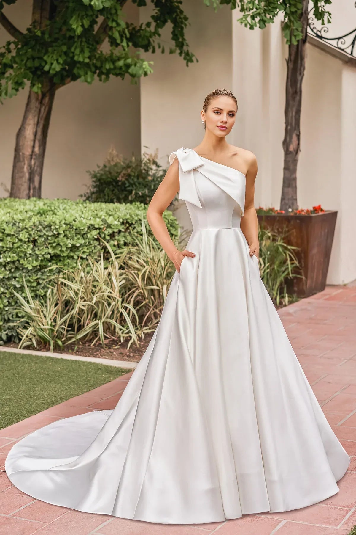 Elegant One‑Shoulder Satin Bow A‑Line Low Back Pocket Pearl Train Garden Wedding Dress