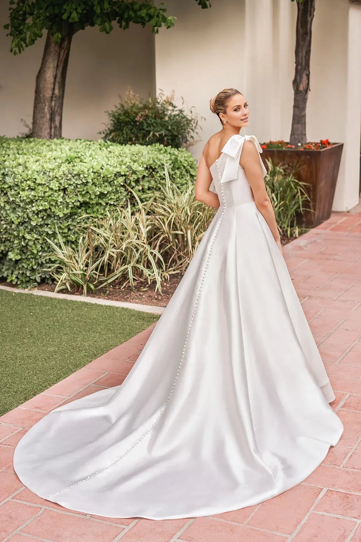 Elegant One‑Shoulder Satin Bow A‑Line Low Back Pocket Pearl Train Garden Wedding Dress